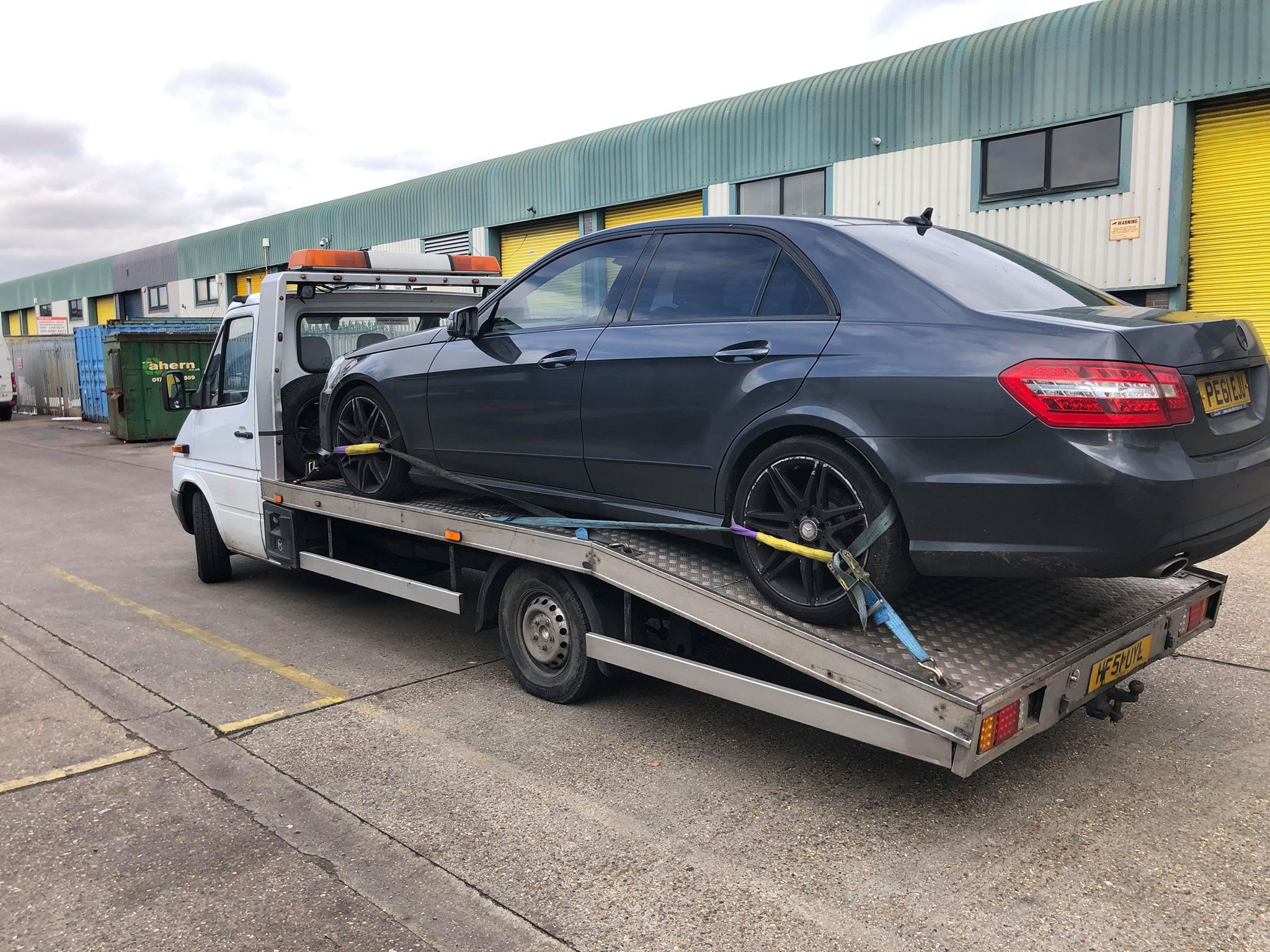 Professional breakdown recovery service with tow truck assisting stranded vehicle on UK motorway - 24/7 roadside assistance